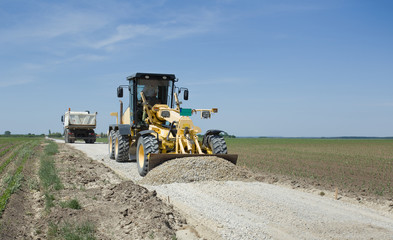 Grader working on gravel leveling