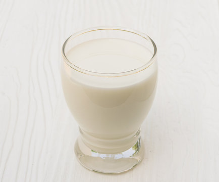 Glass of milk on wood background