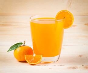 Orange juice and slices on wood