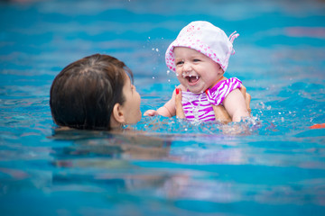 Fototapeta na wymiar family swimming in the pool 