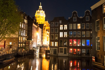 Red light district at night, the Church of St. Nicholas is visible in the distance, the Netherlands.