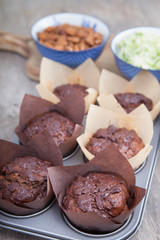 Flourless chocolate courgette muffins in a muffin tin, on a wooden table