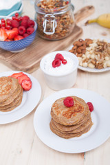 Breakfast: paleo style grain free banana almond pancakes, coconut yogurt with berries, selective focus