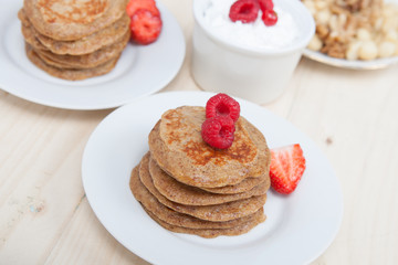 Breakfast: paleo style grain free banana almond pancakes, coconut yogurt with berries, selective focus