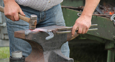A Blacksmith Shaping a Red Hot Horseshoe on an Anvil.