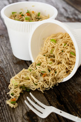 Instant noodles pasta ramen spilled on rustic wood table