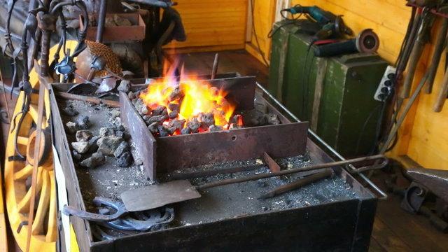 View at forge shop with burning flame and tools near