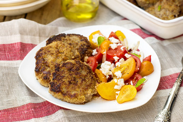 Meatballs with courgette zucchini served with tomato salad