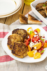 Meatballs with courgette zucchini served with tomato salad