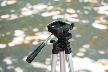 Camera tripod. Photo was taken outdoor in a park.

