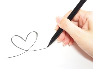 筆ペンでハートを描く女性の手