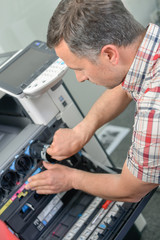 Man repairing a printer
