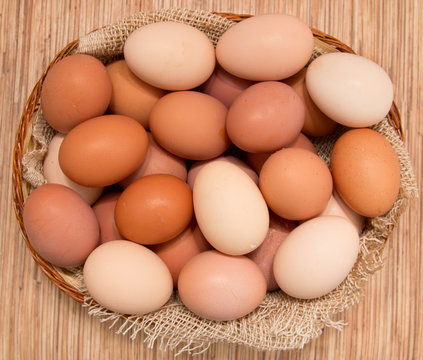 fresh eggs chicken in a basket on a wooden background