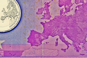 Euro coin on a euro banknote