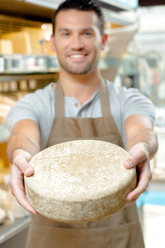 Man holding a wheel of cheese