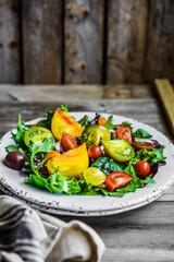 Fresh salad with spinach,arugula and heirloom tomatoes on rustic