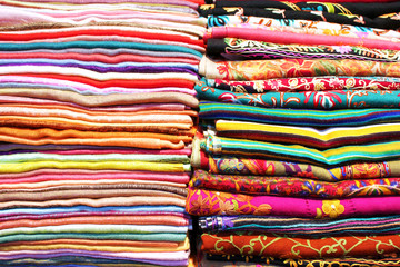 Stacks of colorful scarfs and fabrics background