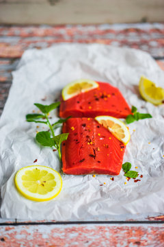 Raw salmon with mint and lemon on rustic background
