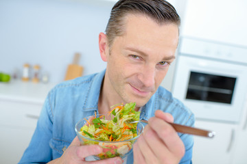 Healthy man eating a salad
