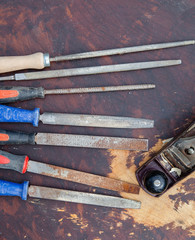Selection of old used chisels and a plane tool on a dark wooden table