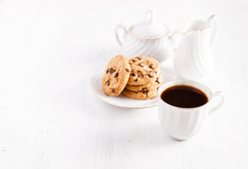 Coffee and chocolate chip cookies on the white table