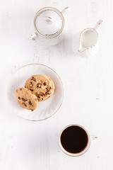 Coffee and chocolate chip cookies on the white table