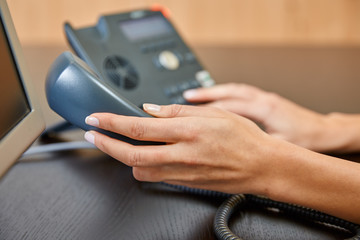 Woman dialing on a telephone