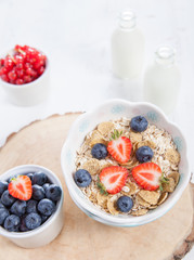 Breakfast: oatmeal cereals with berries on the white wooden table, selective focus