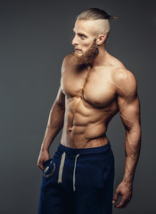 Naklejka premium Muscular shirtless man with beard possing.