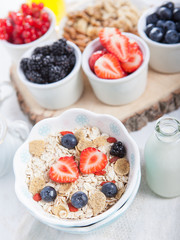 Breakfast: oatmeal cereals with berries on the white wooden table, selective focus