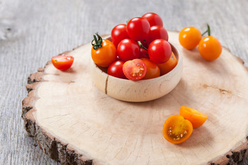 Red and orange cherry tomatoes on the dark wooden table