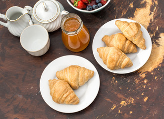 Croissants and jam on the dark wooden table