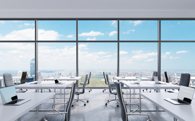 Workplaces in a modern panoramic office, New York city view from the windows. Open space. White...