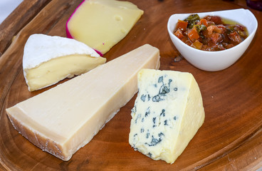 Different types of cheese on wooden kitchen board
