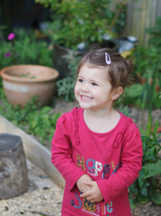 Fototapeta premium A little girl in the garden laughing