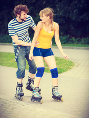 Young couple on roller skates riding outdoors