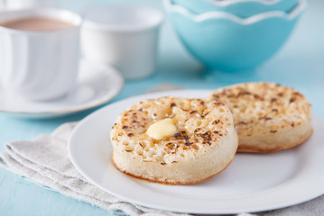 Hot buttered crumpets on the blue table with tea