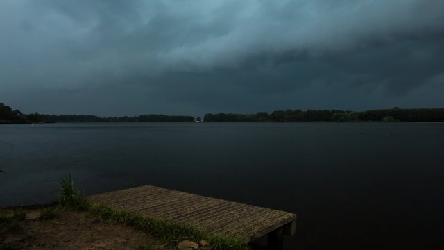 4K Timelapse of a shelf cloud developing above a lake. During the timelapse heavy rain shower, hail, lightning and thunder are visible.