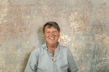 portrait of senior man in front of grungy old wall