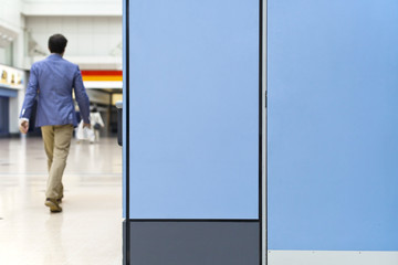 Young Business Man Walking in Corridor, Blue Door Panels in Frame