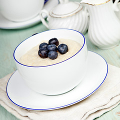 Porridge in breakfast cup on a blue wooden table