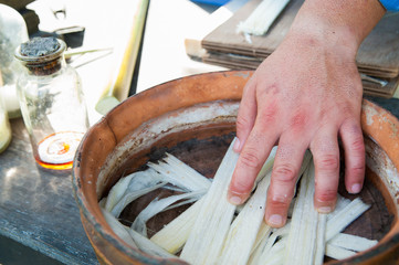 The working of Papyrus: artisan dunking in the water with antioxidant thin strips obtained from the...