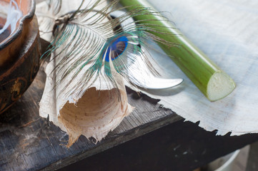 Rolled papyrus paper, quill pen, a section of the plant and the typical knife laid on a papyrus...