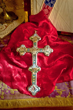 Golden catholic cross on red cloth