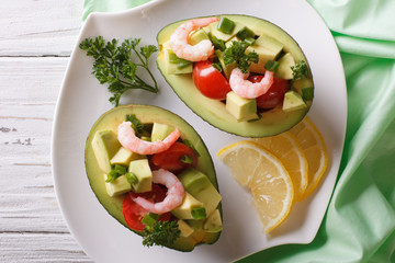 avocado filled with shrimp salad and vegetables closeup. horizontal top view
