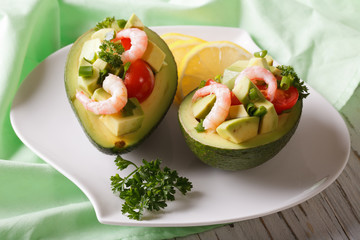 avocado filled with shrimp and vegetables close-up. horizontal
