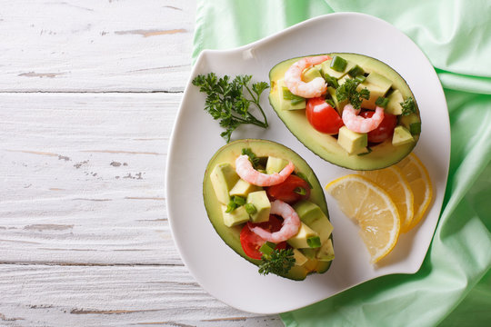 avocado filled with shrimp salad and vegetables. Horizontal top view
