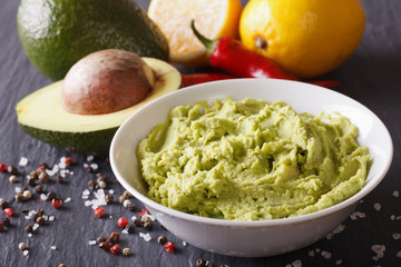 Fresh guacamole sauce with ingredients close-up. horizontal
