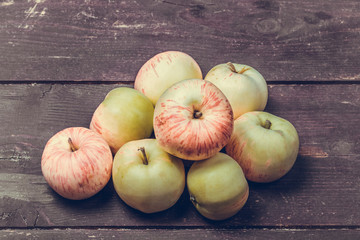 Yellow-red seasonal apples on the background of old boards. Tone