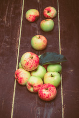 Yellow-red seasonal apples with leaf on the background of old bo